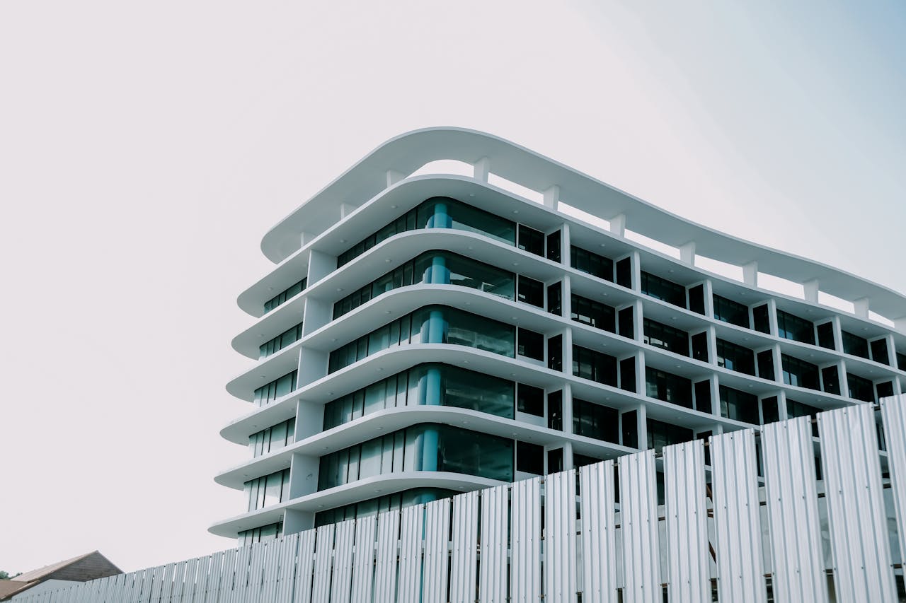 A sleek modern building featuring a distinctive glass facade and flowing lines under a clear sky.